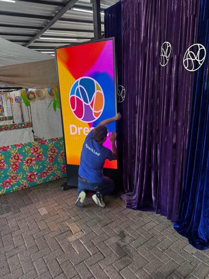 Técnico da Sparkled instalando totem de LED para a Dream n' Learn em evento escolar
